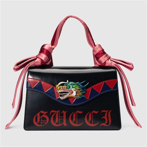 gucci blue sweater yellow dragon|Gucci black leather bag.